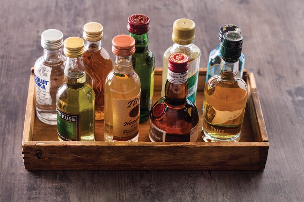 A wooden tray holding bottles of alcohol on top.